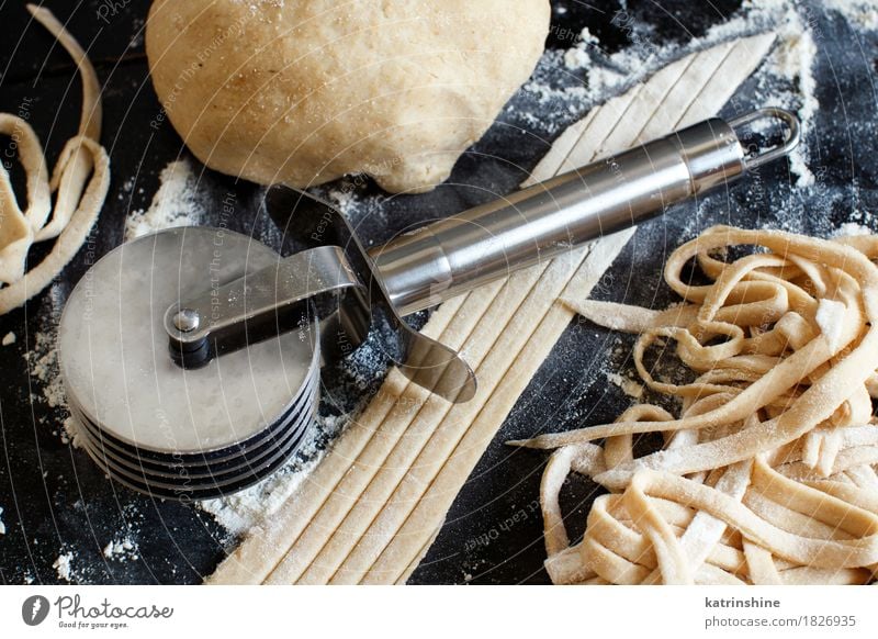 Making hausgemachte Taglatelle mit einer Pasta Rollschneider Teigwaren Backwaren Ernährung Italienische Küche Tisch Werkzeug machen dunkel frisch Tradition