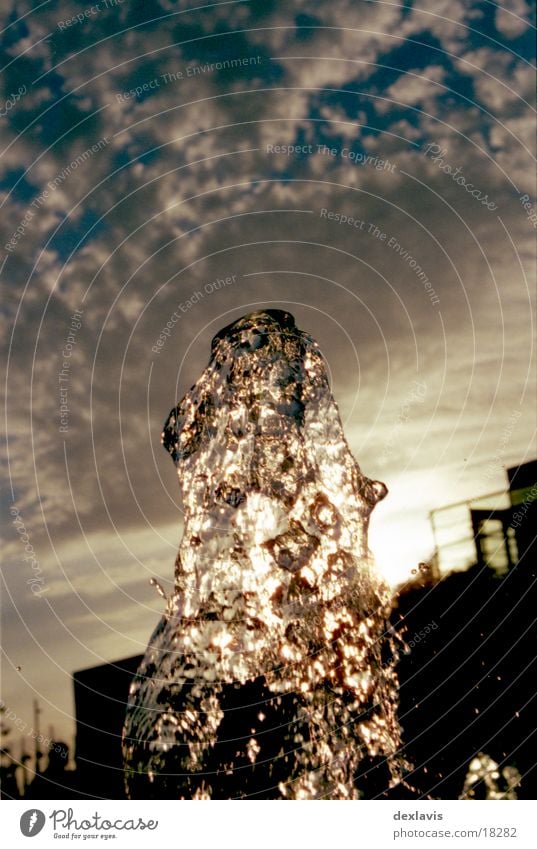 Lichtklumpen Wasserfontäne Springbrunnen Brunnen Sonnenuntergang Gegenlicht Wolken Flüssigkeit nass Wassertropfen frozen ruhig