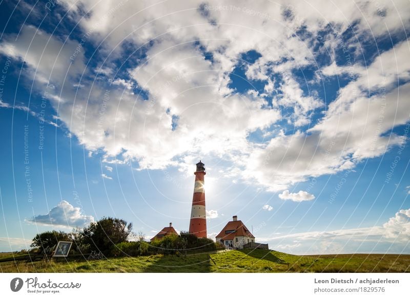 Leuchtturm Himmel Wolken Sonne Frühling Sommer Gras Hügel Haus Sehenswürdigkeit groß blau grün rot weiß Farbfoto Außenaufnahme Menschenleer Textfreiraum links