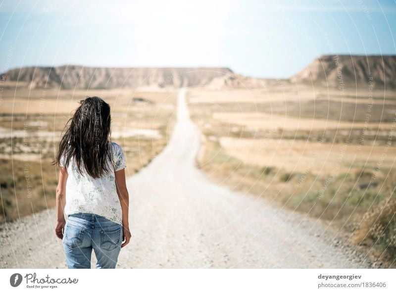 Frau, die auf Schotterweg geht. Erholung Berge u. Gebirge wandern Erwachsene Natur Landschaft Erde Himmel Park Hügel Felsen Straße Jeanshose blau rot Film