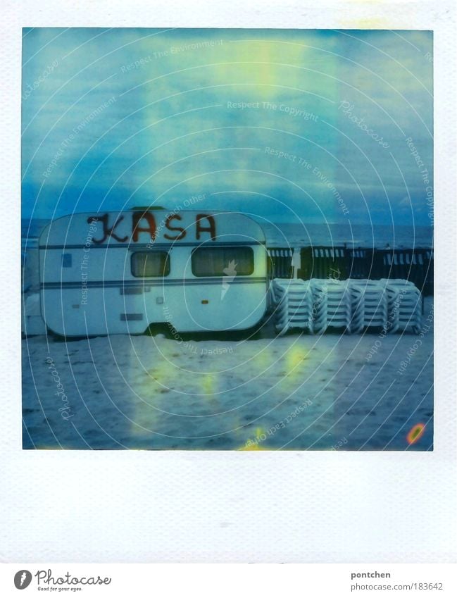 Wohnwagen mit der Aufschrift kasa Kasse steht am Strand. Verleih. Strandliegen. Strandkörbe Farbfoto Gedeckte Farben Außenaufnahme Polaroid Textfreiraum oben