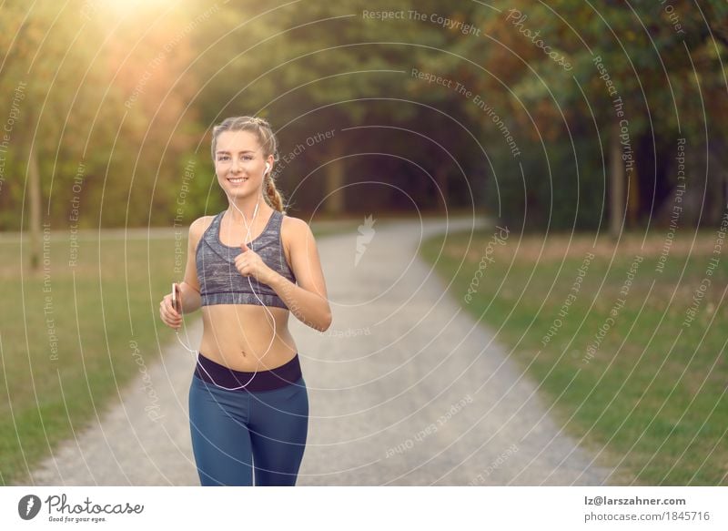 Frau, die entlang einer Landstraße beim Hören Musik rüttelt Lifestyle Glück Sommer Sport Joggen PDA feminin Erwachsene 1 Mensch 18-30 Jahre Jugendliche