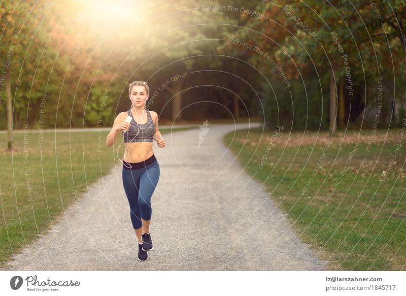 Frau, die entlang einer Landstraße beim Hören Musik rüttelt Lifestyle Glück Sommer Sport Joggen PDA feminin Erwachsene 1 Mensch 18-30 Jahre Jugendliche