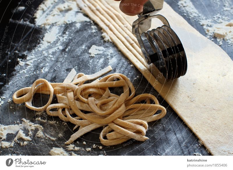 Making hausgemachte Taglatelle mit einer Pasta Rollschneider Teigwaren Backwaren Ernährung Italienische Küche Tisch Werkzeug machen dunkel frisch Tradition