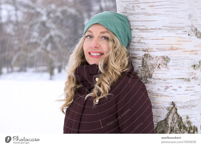 happy woman leaning against tree in winter Lifestyle Freizeit & Hobby Ferien & Urlaub & Reisen Winter Schnee Winterurlaub Mensch feminin Junge Frau Jugendliche