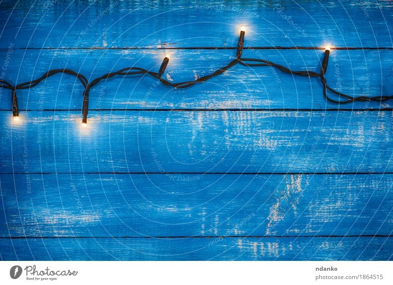 Elektrische Girlande mit leuchtenden Lichtern Dekoration & Verzierung Lampe Silvester u. Neujahr Holz alt dunkel retro blau Hintergrund altehrwürdig elektrisch