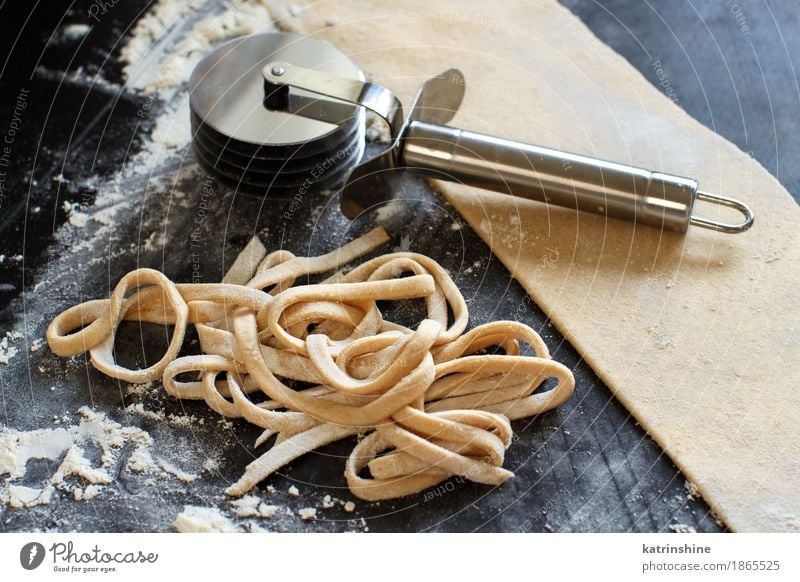 Making hausgemachte Taglatelle mit einer Pasta Rollschneider Teigwaren Backwaren Ernährung Diät Italienische Küche Tisch machen dunkel frisch Tradition Zutaten