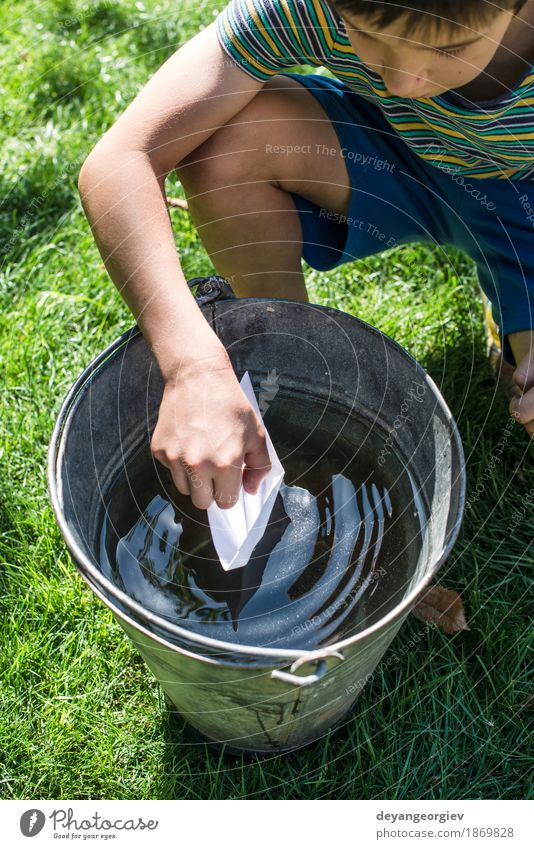 Kinderspiel mit Boot in einem Eimer Wasser Freude Spielen Ferien & Urlaub & Reisen Freiheit Sommer Garten Junge Kindheit Natur Segelboot Wasserfahrzeug Papier