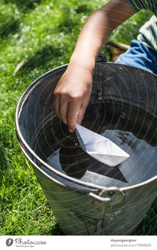 Kinderspiel mit Boot in einem Eimer Wasser Freude Spielen Ferien & Urlaub & Reisen Freiheit Sommer Garten Junge Kindheit Natur Segelboot Wasserfahrzeug Papier