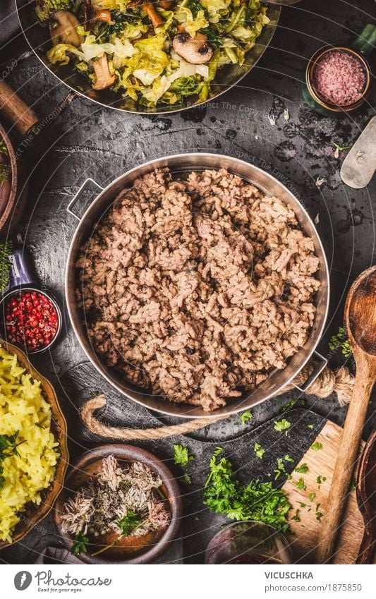 Hackfleisch im Kochtopf auf rustikalem Küchentisch Lebensmittel Fleisch Gemüse Kräuter & Gewürze Öl Ernährung Abendessen Festessen Bioprodukte Geschirr Teller