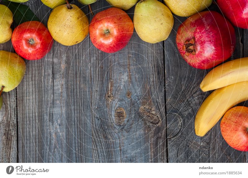 Bananen, Granatäpfel, Äpfel und Birnen auf einer grauen Holzoberfläche Lebensmittel Frucht Apfel Ernährung Essen Mittagessen Vegetarische Ernährung Garten Tisch