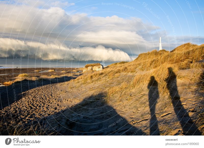 Strandbetrachter Mensch Natur Landschaft Sand Wolken Winter Küste Nordsee Fischerdorf Ruine Bauwerk Beton Ferne kalt blau braun gelb grau schwarz weiß Schatten