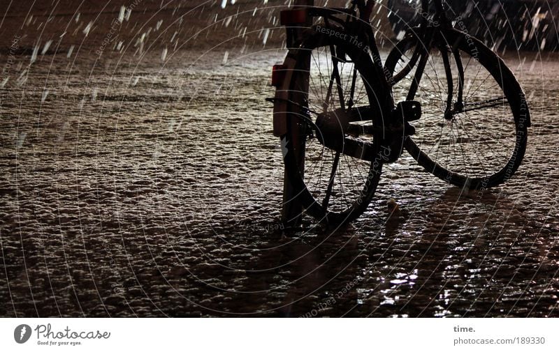 Schneegurke Fahrrad Rad Metall Fahrradrahmen Schutzblech Laternenpfahl Außenaufnahme Kunstlicht Nacht Speichen Unterteil schwarz parken anlehnen stehen Winter