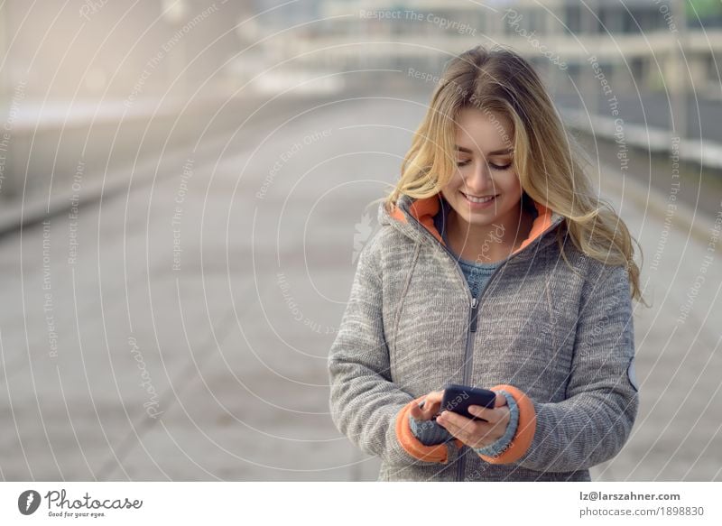 Junge Frau mit dem Handy gehend eine Stadtstraße Lifestyle schön lesen Ferien & Urlaub & Reisen Winter Telefon PDA Technik & Technologie Erwachsene 1 Mensch