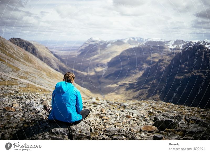 Frau sitzt auf Felsen mit Blick ins Glencoe Tal, Schottland Mittagessen Ferien & Urlaub & Reisen Erwachsene Natur Fitness Abenteuer Erholung erleben