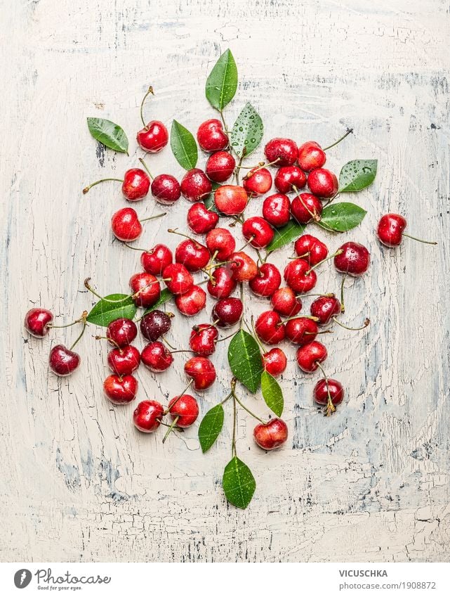 Zerstreute Kirschen mit grünen Blättern Lebensmittel Frucht Ernährung Bioprodukte Vegetarische Ernährung Stil Design Gesundheit Gesunde Ernährung Sommer Tisch