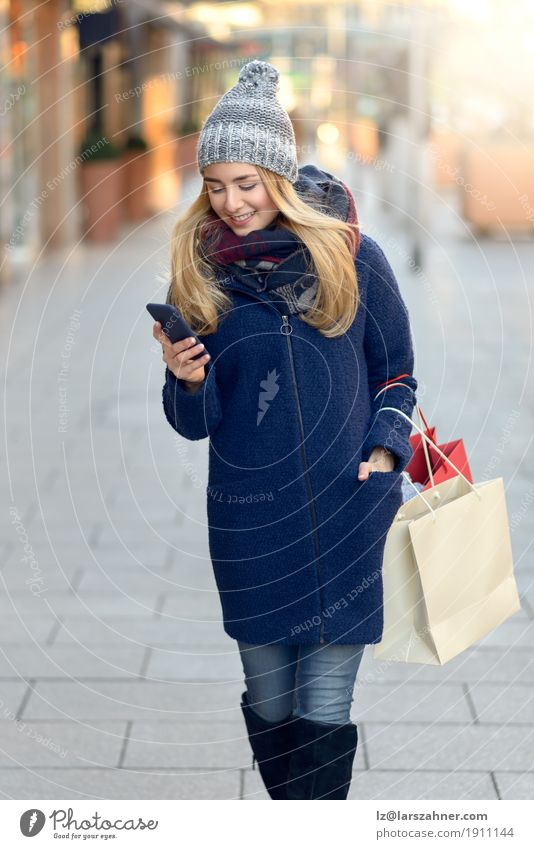 Moderne junge Frau beschäftigt mit ihrem Handy Lifestyle schön lesen Winter Telefon PDA Technik & Technologie Erwachsene 1 Mensch 18-30 Jahre Jugendliche Stadt