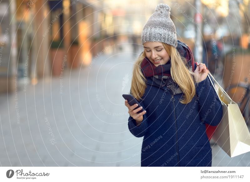 Moderne junge Frau beschäftigt mit ihrem Handy Lifestyle schön lesen Winter Telefon PDA Technik & Technologie Erwachsene 1 Mensch 18-30 Jahre Jugendliche Stadt