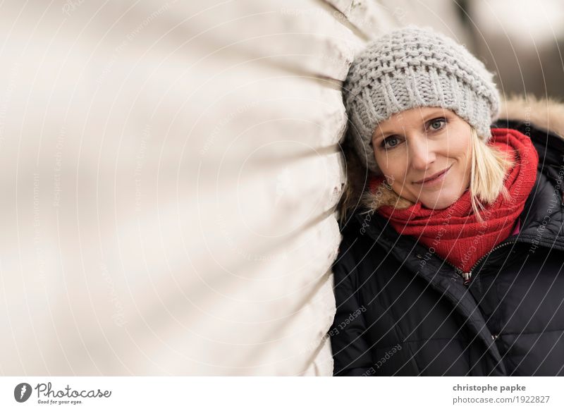 Rotschälchen / Graukäppchen Junge Frau Jugendliche Erwachsene Gesicht 1 Mensch 30-45 Jahre Mauer Wand Mantel Schal Mütze blond Lächeln Blick schön Farbfoto