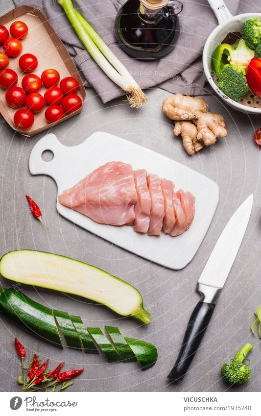 Geschnittene rohe Hähnchenbrustfilet auf weißem Schneidebrett Lebensmittel Fleisch Gemüse Kräuter & Gewürze Öl Ernährung Mittagessen Abendessen Bioprodukte Diät