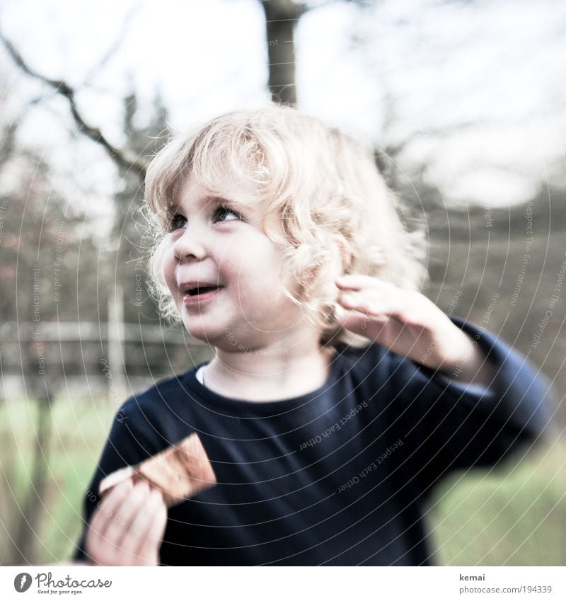 Der Schokoriegel Mensch Kind Kleinkind Mädchen Kindheit Kopf Haare & Frisuren Gesicht Hand 1 1-3 Jahre blond langhaarig Locken Essen genießen Lächeln lachen