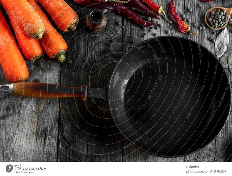 Schwarze Bratpfanne unter dem Frischgemüse Gemüse Kräuter & Gewürze Vegetarische Ernährung Geschirr Pfanne Löffel Tisch Herbst Holz Metall Diät alt Essen frisch