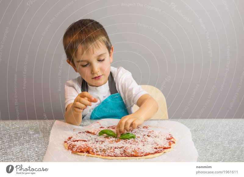 Kleiner Junge macht Pizza und beendet mit Basilikumblättern Käse Teigwaren Backwaren Schalen & Schüsseln schön Freizeit & Hobby Küche Kind Schule Kindheit Hand