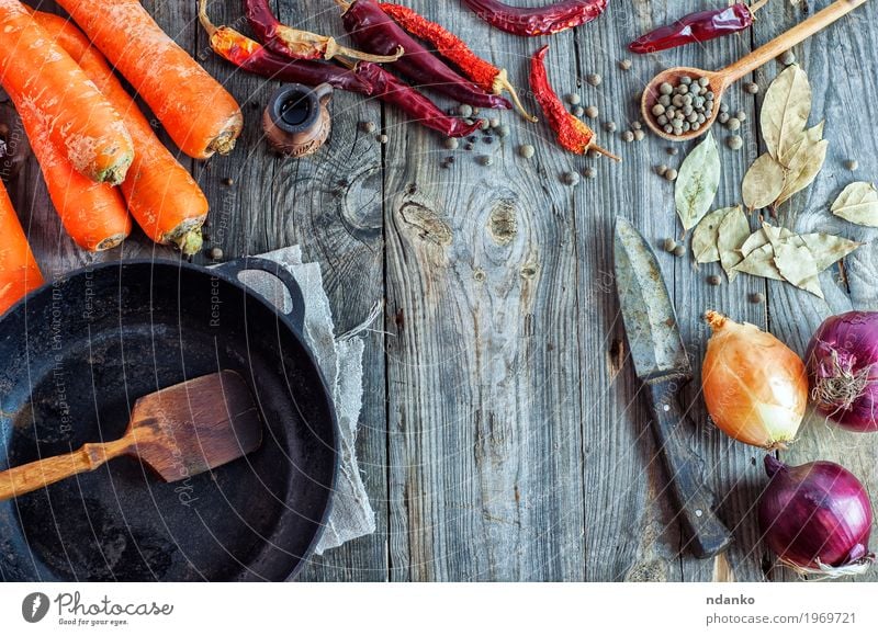 Leere schwarze Bratpfanne und Gemüse Lebensmittel Kräuter & Gewürze Essen Vegetarische Ernährung Pfanne Messer Löffel Tisch Küche Holz alt frisch saftig braun