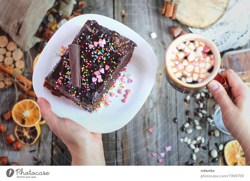 Tasse Kaffee und ein Teller mit Kuchen Sacher in weiblichen Händen Lebensmittel Frucht Dessert Süßwaren Frühstück Getränk Heißgetränk Kakao Besteck