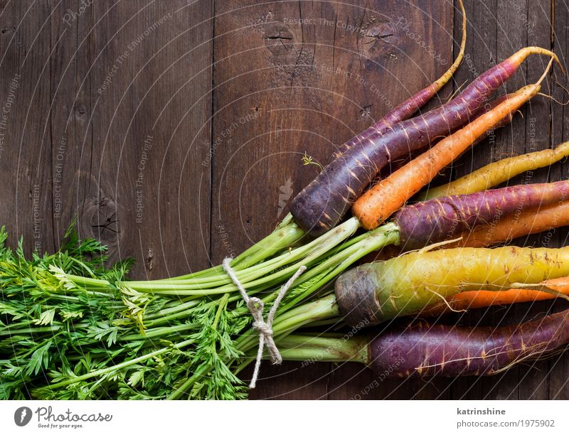 Frische organische Regenbogenkarotten auf einem Holztisch Gemüse Ernährung Vegetarische Ernährung frisch braun gelb Möhre Landwirt Lebensmittel Ernte Gesundheit