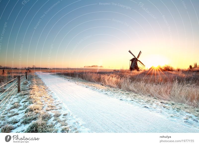 Schnee auf Radweg und Sonne hinter Windmühle Winter Natur Landschaft Himmel Horizont Sonnenaufgang Sonnenuntergang Sonnenlicht Nebel Wiese Straße Wege & Pfade