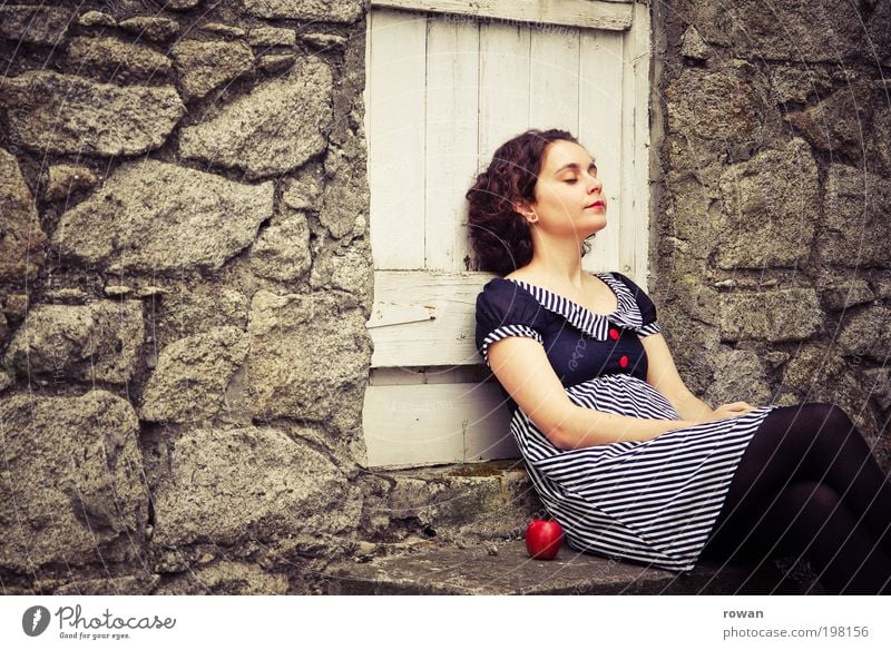 pause Mensch feminin Junge Frau Jugendliche Erwachsene 1 Umwelt Erholung ruhig Pause Apfel rot Frucht Kleid Mauer Tür Garten Landleben altmodisch gestreift