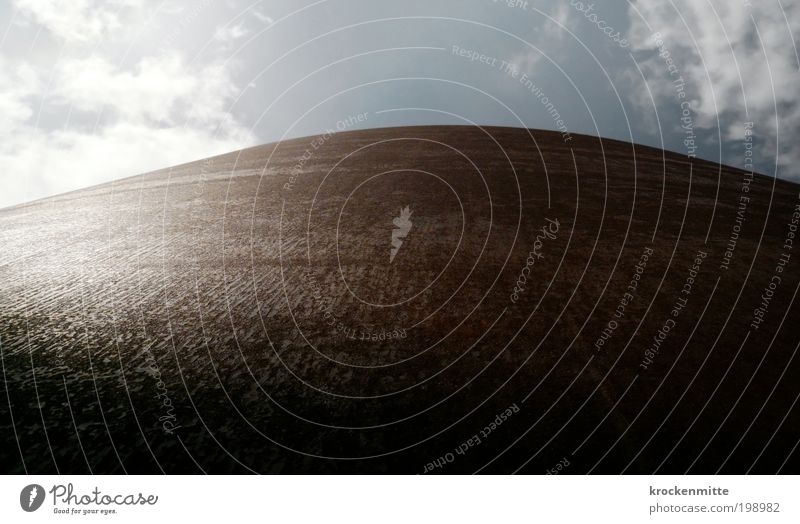 Monolith Kunstwerk Skulptur braun Schutz Horizont Steigung Macht groß Metall Rost Wolken Wolkenhimmel blau Strukturen & Formen Sonnenlicht reflektion rund