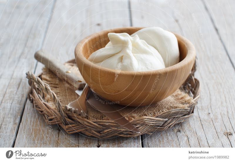 Italienischer Käse Burrata mit Brot auf einem hölzernen Hintergrund Ernährung Vegetarische Ernährung Italienische Küche Schalen & Schüsseln Messer Gabel Holz