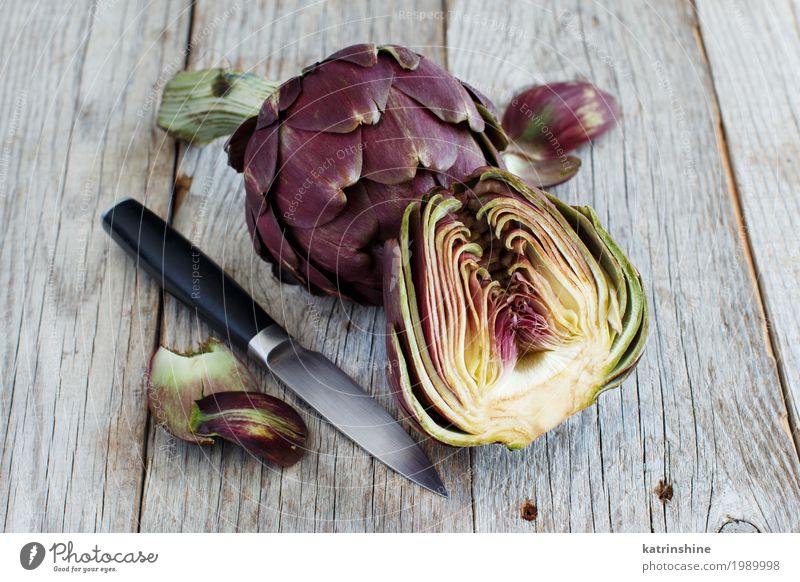 Römische Artischocken auf einem Holzbrett mit Messer Gemüse Ernährung Vegetarische Ernährung frisch grau grün Ackerbau purpur Essen zubereiten geschnitten