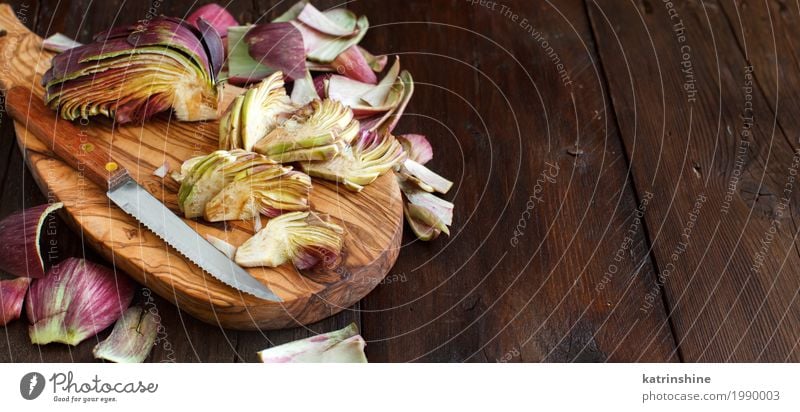 Römische Artischocken auf einem Holzbrett mit Messer Gemüse Ernährung Vegetarische Ernährung frisch grau grün Ackerbau purpur Essen zubereiten geschnitten