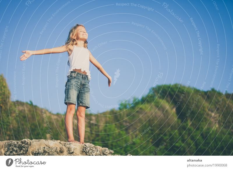 Glückliches kleines Mädchen am Strand stehend am Tag Lifestyle Freude schön Erholung Freizeit & Hobby Spielen Ferien & Urlaub & Reisen Freiheit Sommer Sonne