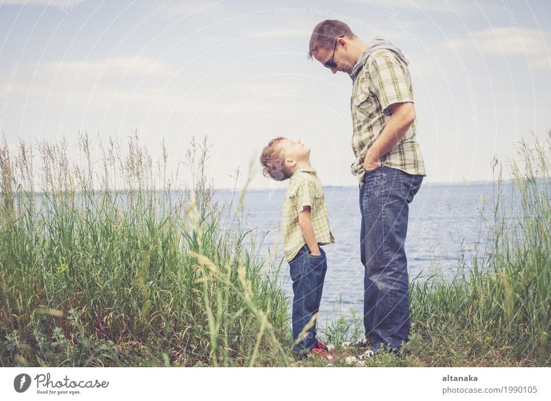 Vater und Sohn, die am Park nahe See zur Tageszeit spielen. Lifestyle Freude Leben Erholung Freizeit & Hobby Spielen Ferien & Urlaub & Reisen Ausflug Freiheit