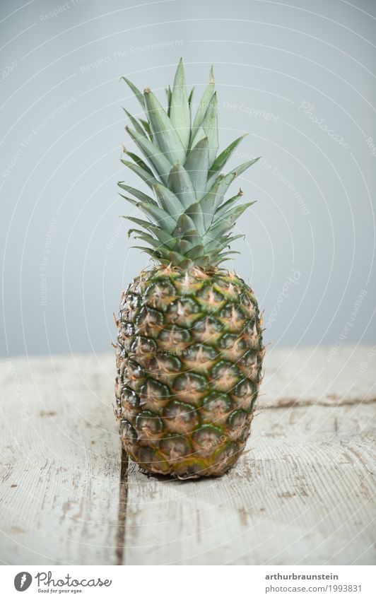 Ananas auf Holztisch Lebensmittel Frucht Ananasblätter Ernährung Frühstück Mittagessen Vegetarische Ernährung Fasten Slowfood Asiatische Küche kaufen Reichtum