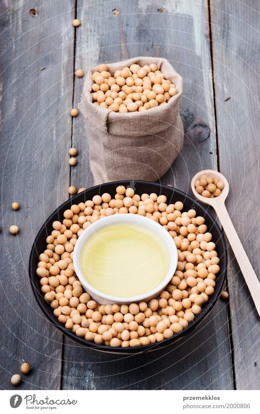 Sojabohnenöl-Bohnen und Sojaöl in den Schüsseln auf Holztisch Ernährung Bioprodukte Vegetarische Ernährung Asiatische Küche Schalen & Schüsseln Löffel Container