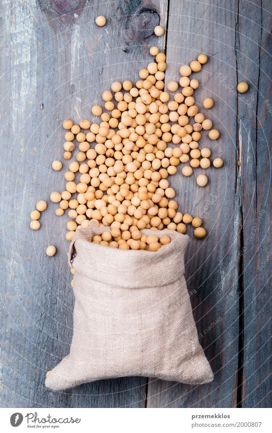 Sojabohnenölbohnen in einem Sack auf Holztisch Getreide Ernährung Bioprodukte Vegetarische Ernährung Asiatische Küche Container frisch Gesundheit natürlich