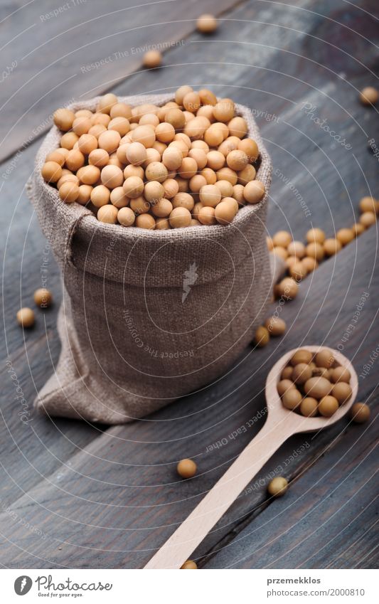 Sojabohnenölbohnen in einem Sack auf Holztisch Getreide Ernährung Bioprodukte Vegetarische Ernährung Löffel frisch Gesundheit natürlich Bohnen Ballaststoff