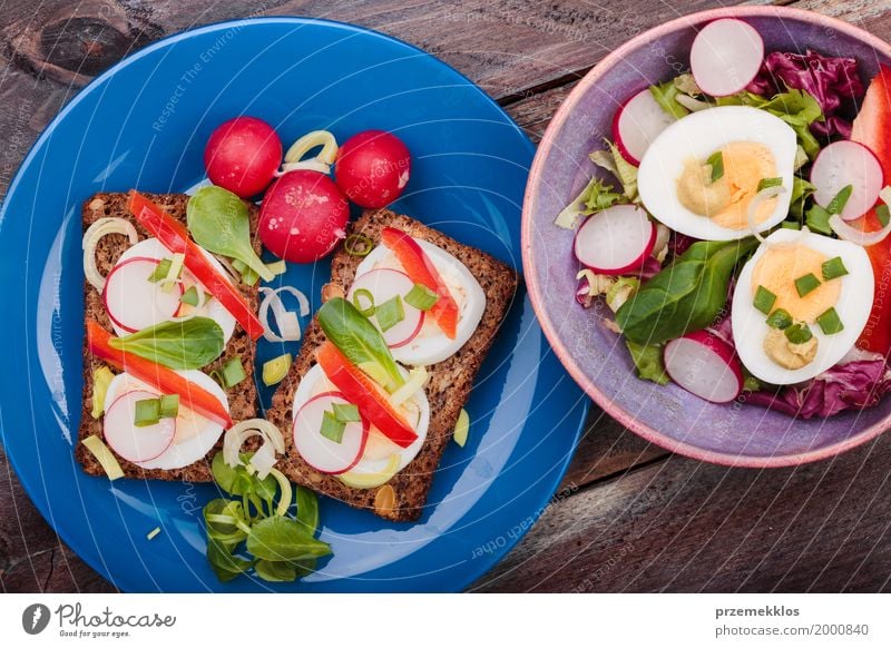 Gesunde Mahlzeit mit Eiern und Gemüse Lebensmittel Salat Salatbeilage Brot Mittagessen Vegetarische Ernährung Diät Schalen & Schüsseln Tisch Holz frisch