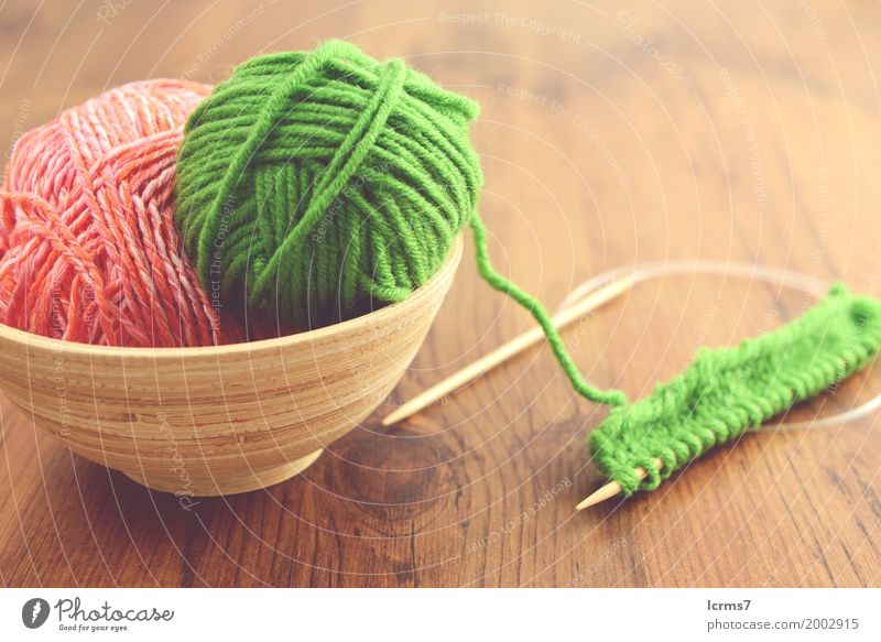 knitting with green and pink wool in a bowl on wooden table. Design Freizeit & Hobby Winter Wärme Mode Wolle stricken Kreativität yarn craft Hintergrundbild