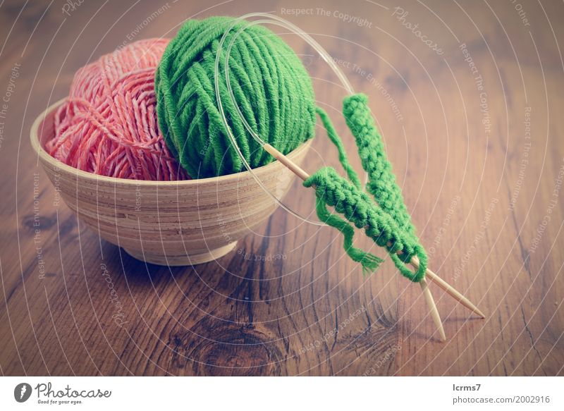 knitting with green wool in a bowl on wooden table Design Freizeit & Hobby Winter Wärme Mode Wolle stricken Kreativität yarn craft Hintergrundbild handmade