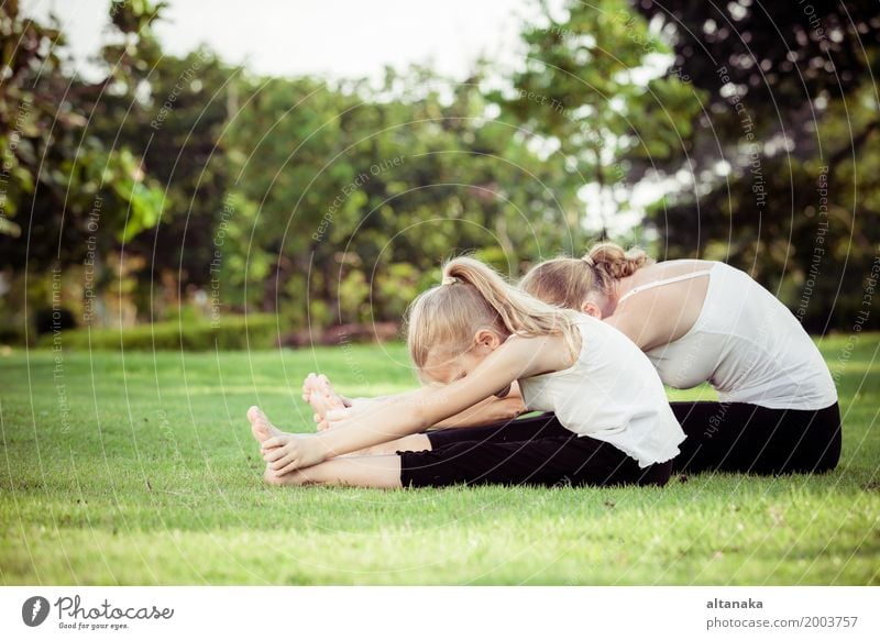 Mutter und Tochter tun Yoga-Übungen auf Gras im Park am Tag Zeit Lifestyle Freude Glück schön Körper Wellness stimmig Erholung Meditation Freizeit & Hobby