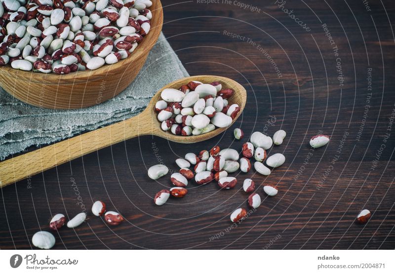 Bohnen in einem hölzernen Löffel auf einem Holztisch Gemüse Ernährung Essen Vegetarische Ernährung Diät Schalen & Schüsseln Menschengruppe frisch lecker braun