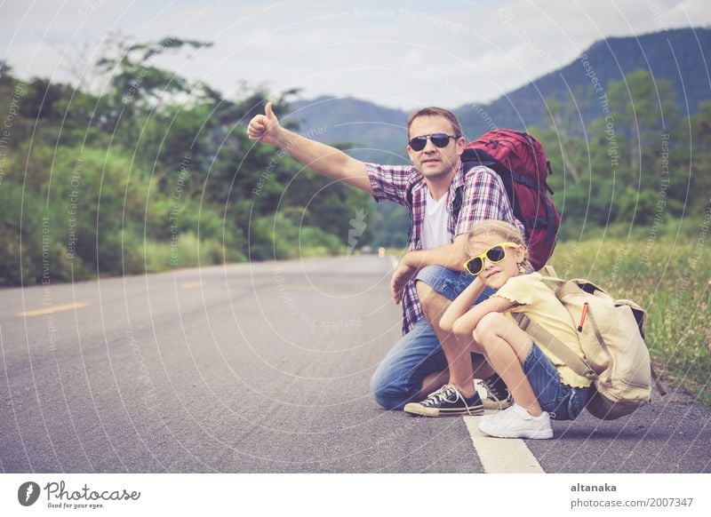 Vater und Tochter, die auf die Straße zur Tageszeit gehen. Lifestyle Freude Glück Freizeit & Hobby Ferien & Urlaub & Reisen Ausflug Abenteuer Freiheit Sommer