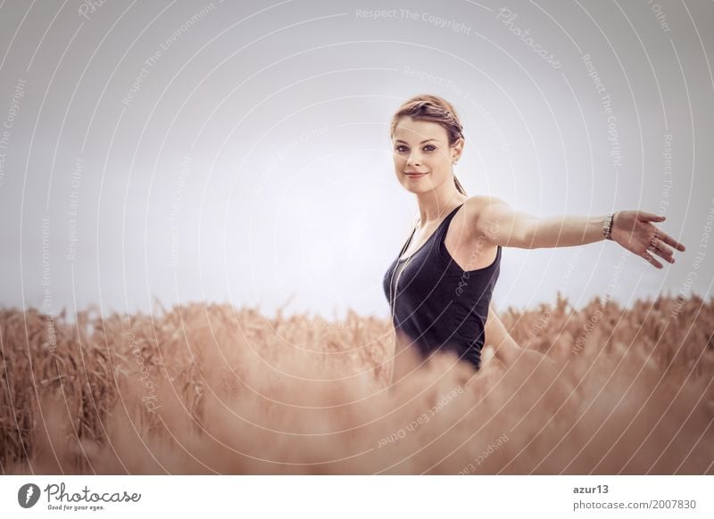 Schöne junge Frau im Herbst auf Getreide Feld bis zum Horizont. Hübsches Mädchen mit Lebensfreude geniesst die Sonnenschein Pause und das Leben. Erholung und Energie tanken vom Zeit Stress in der Umwelt und Natur Idylle. Blick in die Kamera.