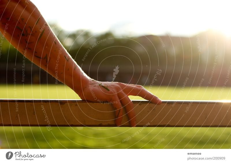 grasarm Sonne Sportstätten Fußballplatz Mensch maskulin Arme Hand Finger 1 Gras festhalten nass Wärme Kraft Geländer Metall feucht Unterarm Farbfoto mehrfarbig